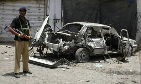 A policeman stands guard at the site of a bomb blast at a market in Dera Ismail Khan. The latest in a string of bombs in northwest Pakistan killed eight people Sunday as a US missile strike hit a tribal belt where troops are expected to launch a fresh anti-Taliban onslaught. [Xinhua/Reuters]