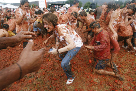 Revellers play with tomato pulp during the annual 'Tomatina' (tomato fight) in Sutamarchan Province Boyaca June 14,2009.[Xinhua/Reuters] 