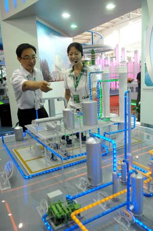 A worker introduces an engineering model to a visitor at the China International Energy Saving and Environmental Protection Exhibition 2009 in Beijing, capital of China, June 14, 2009. The exhibition kicked off on Sunday and attracted over 250 enterprises from home and abroad. [Xinhua]