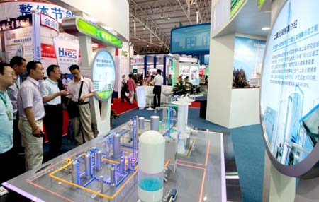 Visitors view a model of a carbon dioxide collecting system of a power plant at the China International Energy Saving and Environmental Protection Exhibition 2009 in Beijing, capital of China, June 14, 2009. The exhibition kicked off on Sunday and attracted over 250 enterprises from home and abroad.[Xinhua]