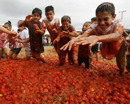 Revellers play with tomato pulp during the annual 'Tomatina' (tomato fight) in Sutamarchan Province Boyaca June 14, 2009. [Xinhua/Reuters] 