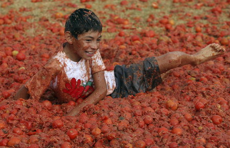 Revellers play with tomato pulp during the annual 'Tomatina' (tomato fight) in Sutamarchan Province Boyaca June 14, 2009. [Xinhua/Reuters] 