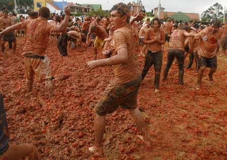 Revellers play with tomato pulp during the annual 'Tomatina' (tomato fight) in Sutamarchan Province Boyaca June 14, 2009. [Xinhua/Reuters] 