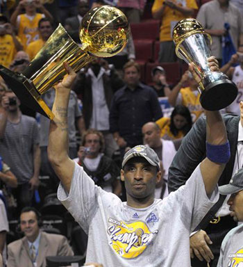 Los Angeles Lakers Kobe Bryant holds up the Bill Russell MVP Award (R) and the Larry O'Brien Trophy as he signals his four career championship victories after they defeated the Orlando Magic to win the NBA basketball championship in Orlando, Florida, June 14, 2009. [Xinhua]