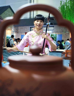 A girl performs erhu, Chinese traditional two-stringed musical instrument, at the 2009 Zhejiang (Shanghai) Travel Fair in Shanghai, east China, June 12, 2009. (Xinhua Photo)
