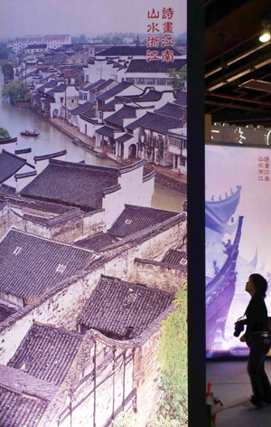 A visitor views a photo of an ancient town at the 2009 Zhejiang (Shanghai) Travel Fair in Shanghai, east China, June 12, 2009. (Xinhua Photo)