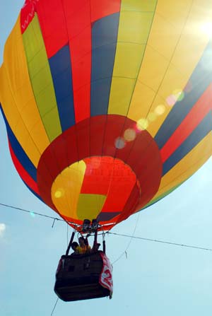 A hot air balloon takes off from a park in Haikou, capital city of south China's Hainan Province, on the first day of the 2009 Haikou International Hot Air Balloon Festival on June 12, 2009.(Xinhua Photo)