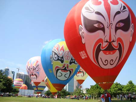 Hot air balloons painted with Chinese Pekin Opera facial make-ups prepare to take off from a park in Haikou, capital city of south China&apos;s Hainan Province, on the first day of the 2009 Haikou International Hot Air Balloon Festival on June 12, 2009. [Xinhua Photo]