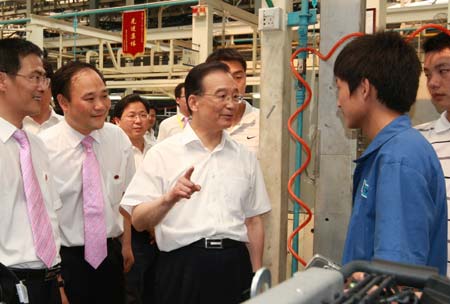 Chinese Premier Wen Jiabao (C), also a member of the Standing Committee of the Political Bureau of the Communist Party of China (CPC) Central Committee, talks with employees of Geely Automobile Parts Co.,Ltd in central China's Hunan Province, on June 13, 2009. Premier Wen made an inspection tour in Hunan Province from June 12 to June 14.