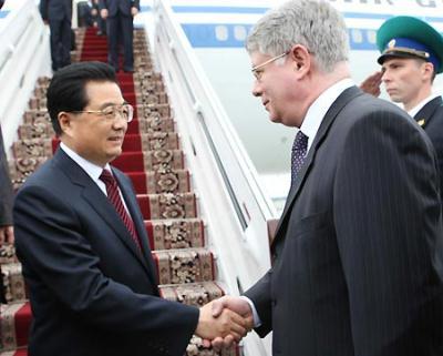 Chinese President Hu Jintao (L) is welcomed by Russian Deputy Foreign Minister Alexei Borodavkin upon his arrival in Jekaterinburg, Russia, on June 14, 2009, for a summit of the Shanghai Cooperation Organization (SCO) and a meeting of BRIC countries, namely Brazil, Russia, India and China. [Lan Hongguang/Xinhua]