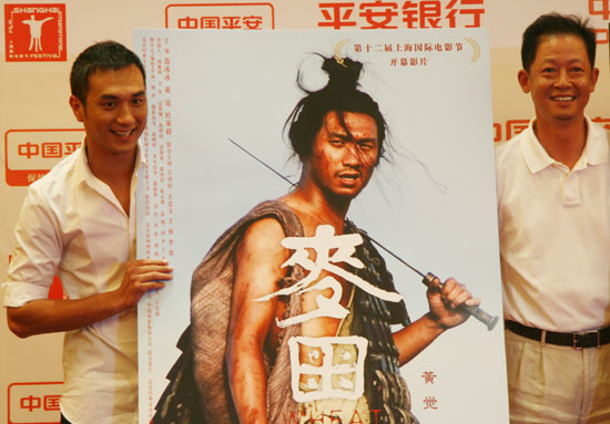 Cast members Huang Jue (L) and Wang Zhiwen pose with a poster of 'Wheat' at a press conference in Shanghai on June 12, 2009.