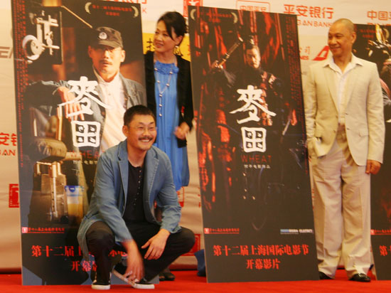 Director He Ping (L) and cast members Wang Ji (C) and Wang Xueqi pose with posters of 'Wheat' at a press conference in Shanghai on June 12, 2009. 