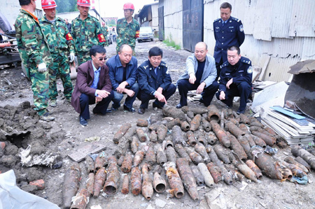 Experts count shells abandoned by Japanese invading troops at a porcelain market in Mudanjiang, a city in northeast China's Heilongjiang Province, June 15, 2009. A total of 95 shells abandoned by Japanese invading troops were excavated in Mudanjiang on Monday. [Xinhua]