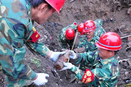 People unearth shells abandoned by Japanese invading troops at a porcelain market in Mudanjiang, a city in northeast China's Heilongjiang Province, June 15, 2009. A total of 95 shells abandoned by Japanese invading troops were excavated in Mudanjiang on Monday. [Xinhua]