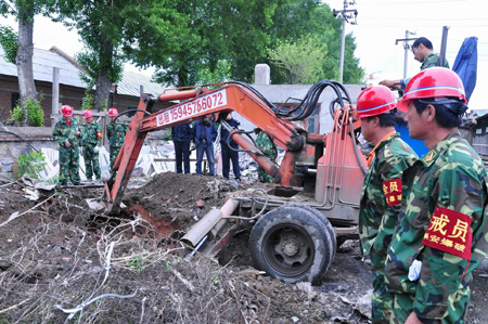 The excavator works to unearth shells abandoned by Japanese invading troops at a porcelain market in Mudanjiang, a city in northeast China's Heilongjiang Province, June 15, 2009. A total of 95 shells abandoned by Japanese invading troops were excavated in Mudanjiang on Monday. [Xinhua]