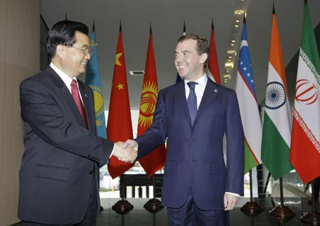  Russian President Dmitry Medvedev (L) shakes hands with China's President Hu Jintao before the start of the Shanghai Cooperation Organization (SCO) summit in the Urals city of Yekaterinburg June 15, 2009. [China Daily]