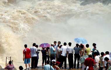 Sightseers view the spectacular torrential Hukou (Kettle Mouth) Waterfall on the Yellow River in Yichuan, northwest China's Shaanxi Province, June 14, 2009. [Xinhua]