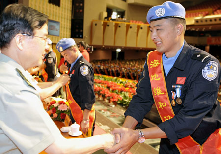 Members of the seventh squad of Chinese peacekeeping riot police in Haiti are awarded in Urumqi, capital of Xinjiang Uygur Autonomous Region, northwestern China, June 16, 2009. The Chinese Ministry of Public Security and Xinjiang local authority held an awarding ceremony for the seventh squad Tuesday. The 125-member squad returned home in Urumqi on June 15. They came from the border police of the Xinjiang Public Security Department. (Xinhua/Zhao Ge) 