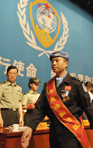 A member of the seventh squad of Chinese peacekeeping riot police in Haiti walks off stage after being awarded in Urumqi, capital of Xinjiang Uygur Autonomous Region, northwestern China, June 16, 2009. (Xinhua/Zhao Ge)