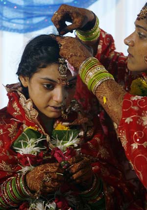 Muslim brides prepare for a mass wedding ceremony in Mumbai June 15, 2009. A total of 30 Muslim couples, from various parts of western Indian state of Maharashtra, took their wedding vows on Monday during the day-long mass marriage ceremony.[Xinhua/Reuters]