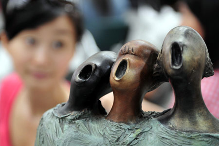 Visitors view exhibits on the 2009 China (Hangzhou) International Annals Exhibition held at the West Lake Expo Museum in Hangzhou, capital of east China's Zhejiang Province, June 16, 2009. [Xinhua]