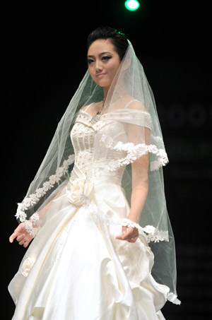 A model displays a wedding dress during the 2009 China Qingdao international fashion week in Qingdao, eastern China's Shandong Province, June 15, 2009. [Li Ziheng/Xinhua]