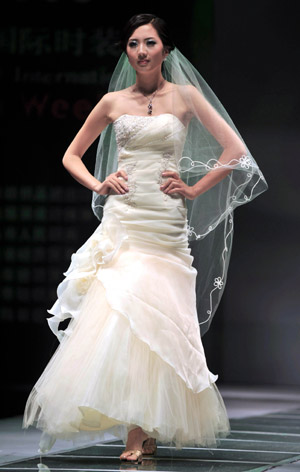 A model displays a wedding dress during the 2009 China Qingdao international fashion week in Qingdao, eastern China's Shandong Province, June 15, 2009. [Li Ziheng/Xinhua]