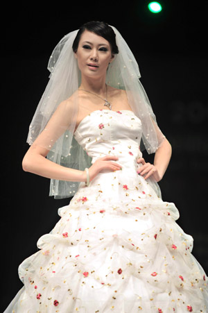 A model displays a wedding dress during the 2009 China Qingdao international fashion week in Qingdao, eastern China's Shandong Province, June 15, 2009. [Li Ziheng/Xinhua]