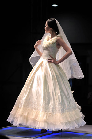 A model displays a wedding dress during the 2009 China Qingdao international fashion week in Qingdao, eastern China's Shandong Province, June 15, 2009. [Li Ziheng/Xinhua]