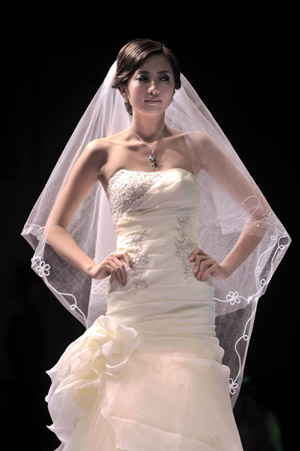 A model displays a wedding dress during the 2009 China Qingdao international fashion week in Qingdao, eastern China's Shandong Province, June 15, 2009. [Li Ziheng/Xinhua]