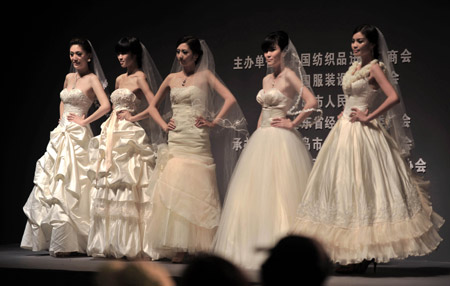 Models display wedding dresses during the 2009 China Qingdao international fashion week in Qingdao, eastern China's Shandong Province, June 15, 2009. [Li Ziheng/Xinhua] 