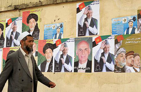 People walk past the posters of presidential candidates in Kabul, June 16. Afghanistan Independent Election Commission (IEC) on Tuesday announced that the presidential candidates can launch election campaign which would last from June 16 to August 17.[Xinhua/AFP]