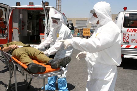 Israeli hospital personnel wearing protective gear take part in a drill simulating an attack by unconventional weapons at Hadassah Ein Kerem hospital in Jerusalem June 16, 2009. [Xinhua]