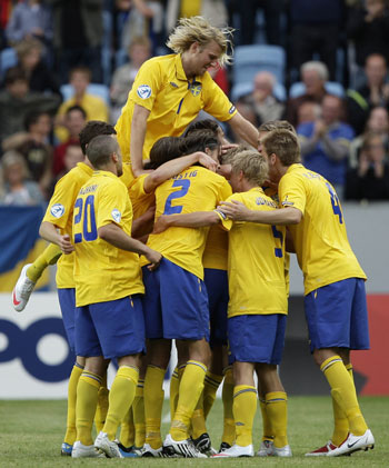 Sweden's Rasmus Elm is mobbed by teammates as they celebrate his goal against Belarus during their U21 European Championship soccer match at Malmo New Stadium in Malmo June 16, 2009.[Xinhua/Reuters]