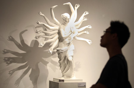A visitor views a sculpture named 'Venus' at an exhibition for graduates of China Academy of Art in Hangzhou, capital of southeast China's Zhejiang Province, June 16, 2009.(Xinhua) 