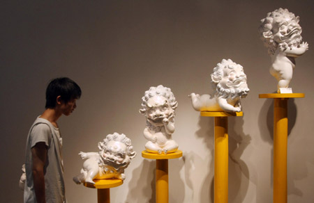 A visitor views a sculpture named 'Dancing lions' at an exhibition for graduates of China Academy of Art (Xinhua) 