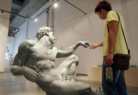 A visitor views a sculpture named 'Create Adam' at an exhibition for graduates of China Academy of Art in Hangzhou, capital of southeast China's Zhejiang Province, June 16, 2009. (Xinhua)