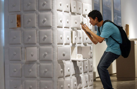 A visitor takes photo for an art installation named &apos;Quality, Feeling&apos; at an exhibition for graduates of China Academy of Art in Hangzhou, capital of southeast China&apos;s Zhejiang Province, June 16, 2009. (Xinhua)