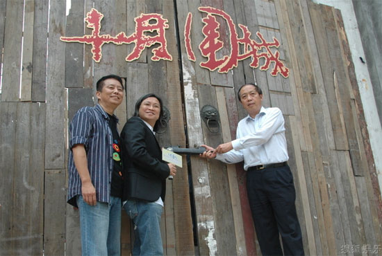  'Bodyguards and Assassins' producer Peter Ho-Sun Chan (C) opened the old door to the film set in Songjiang, Shanghai, on Monday, June 16, 2009. 