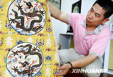 Craftsman Wang Jianjiang shows the imperial robe on June 17, 2009.