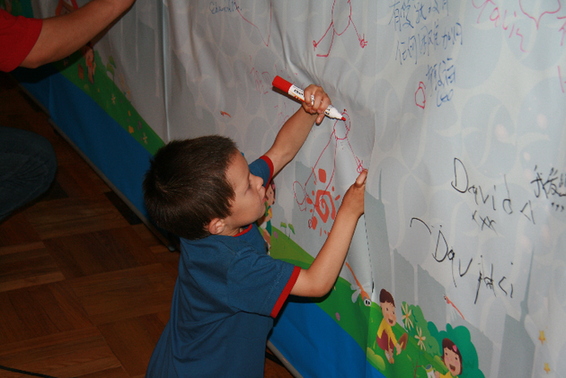 A youngster adds his personal wishes to the Heng An banner that will accompany Katie to Sichuan. 
