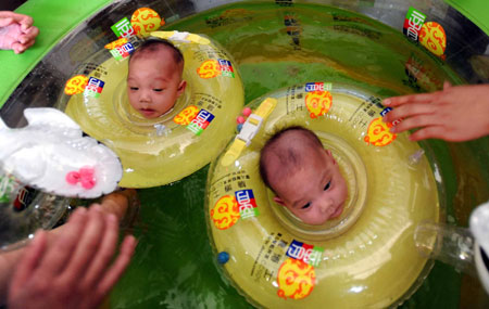 The separated siamese twin sisters swim at the Hunan Children's Hospital in Changsha, capital of central China's Hunan Province, June 18, 2009. The separated siamese twin sisters left the hospital on Thursday after fully recovered from the surgery. Doctors at the Hunan Children's Hospital successfully separated the twins on April 1. The girls were born on March 16 connected from their breastbones to their abdomens.[Xinhua]