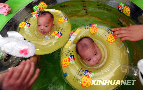 The separated siamese twin sisters swim at the Hunan Children's Hospital in Changsha, capital of central China's Hunan Province, June 18, 2009. The separated siamese twin sisters left the hospital on Thursday after fully recovered from the surgery. Doctors at the Hunan Children's Hospital successfully separated the twins on April 1. The girls were born on March 16 connected from their breastbones to their abdomens.[Li Ga/Xinhua]