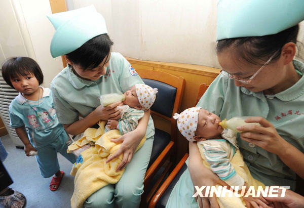 The separated siamese twin sisters drink at the Hunan Children's Hospital in Changsha, capital of central China's Hunan Province, June 18, 2009. [Li Ga/Xinhua]