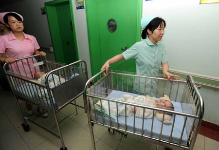 The separated siamese twin sisters leave a ward at the Hunan Children's Hospital in Changsha, capital of central China's Hunan Province, June 18, 2009. [Li Ga/Xinhua]