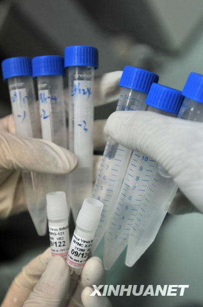 Researchers inoculate the virus strains of the influenza A/H1NI for cuvette cultivation of its vaccination, at a lab of the Wuhan Institute of Biological Products in Wuhan, central China's Hubei Province, June 17, 2009. [Zhou Chao/Xinhua]