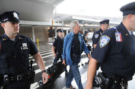 Passengers of Continental Airlines 61 flight leave the Newark Liberty International Airport under the escort of police in New Jersey of the United States, June 18, 2009. [Shen Hong/Xinhua]