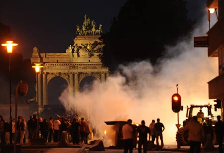 Protestors set fire to haystack during the protest for a fair milk price outside the European Union headquarters in Brussels, capital of Belgium, on late June 18, 2009. [Wu Wei/Xinhua]