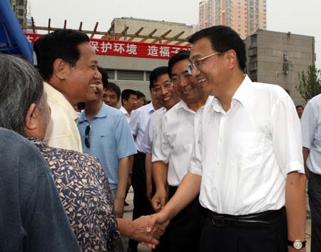 Chinese Vice Premier Li Keqiang, who is also a member of the Standing Committee of the Political Bureau of the Communist Party of China (CPC) Central Committee, talks with a local resident at Xigong community during an occasion marking the national energy-saving awareness week, in Luoyang in central China's Henan Province, June 17, 2009. 