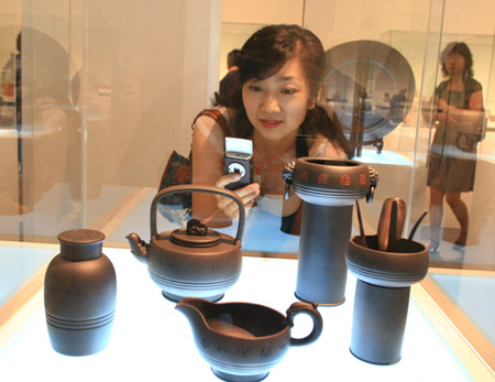 A visitor takes photo of a pottery created by the artistic master Bao Zhiqiang in the National Art Museum of China in Beijing, China, June 20, 2009. An exhibition of Yixing ceramics was held in the National Art Museum of China in Beijing on Saturday, where over 200 pieces of ceramic artworks designed by Chinese ceramic masters were displayed. Yixing is famous for its ceramics. (Xinhua/Ding Huanxin)